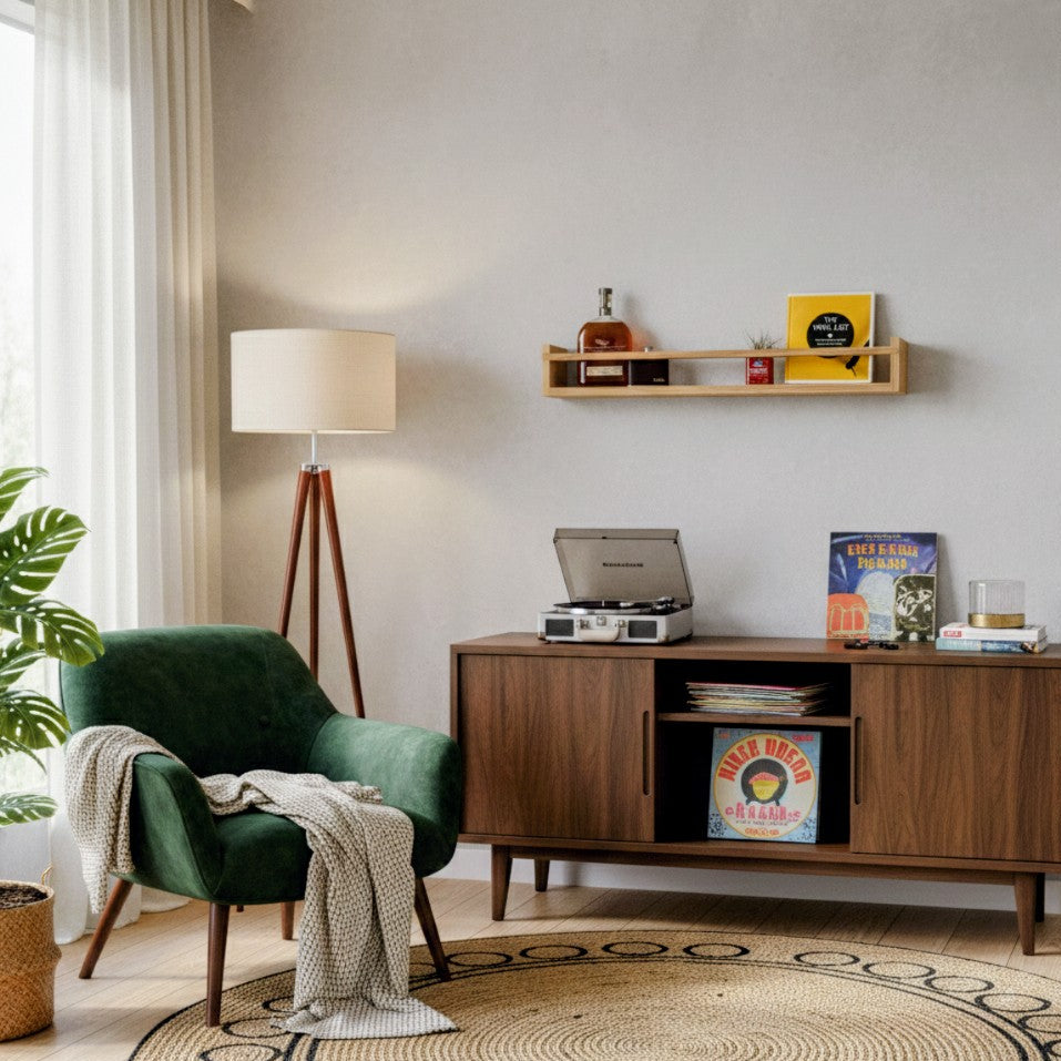Living room with a green armchair, wooden sideboard, and shelf with decorative items.
